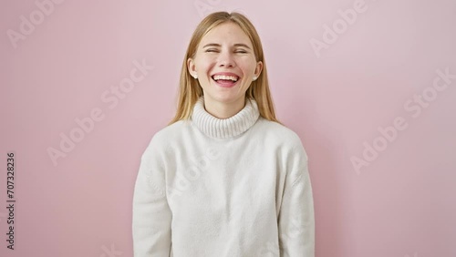 Crazy fun with beautiful blonde girl, making a comical fish face expression over a pink isolated background. standing out with her comical lips gesture. photo