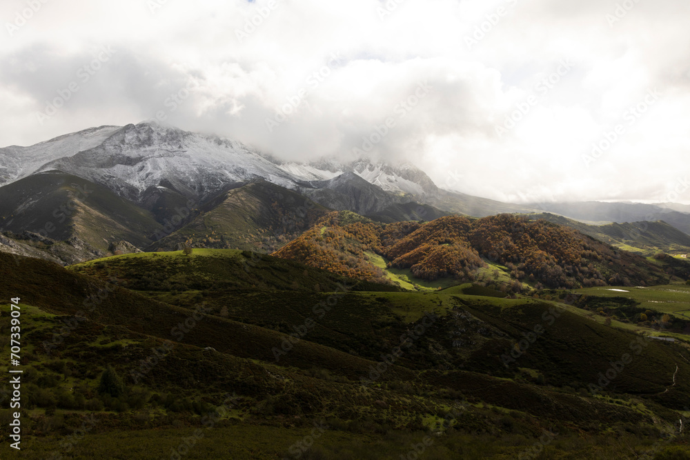 Panoramic landscape of natural park in northern Spain Cantabrian mountain range with peaks and autumn forest on a cloudy overcast day Panoramic landscape of natural park in northern Spain Cantabrian mountain range with peaks and autumn forest on a cloudy overcast day