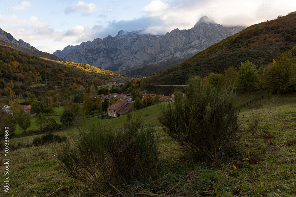 Panoramic landscape of Peaks of Europe in spanish national park at sunrise with autumn bright forest with yellow and orange
