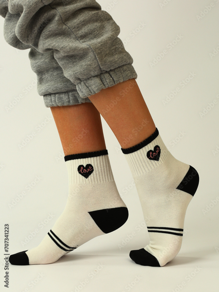 white socks with black heart on human foot close up photo on white background