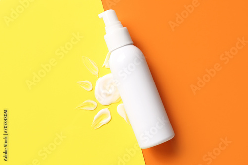 Drawing of sun made with sunscreen cream on color background photo