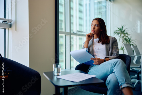 Pensive female entrepreneur working on business reports in office.