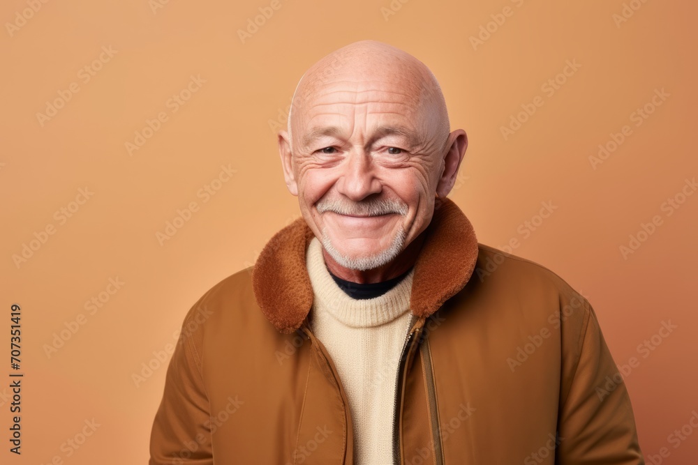Portrait of a smiling senior man in a brown jacket on a orange background Portrait of a smiling senior man in a brown jacket on a orange background