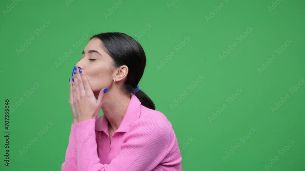 Lively Caucasian woman spreads joy by sending air kisses in all directions, creating a whimsical and heartwarming scene. Celebration of positivity and affection, captured over green background. Lively Caucasian woman spreads joy by sending air kisses in all directions, creating a whimsical and heartwarming scene. Celebration of positivity and affection, captured over green background.