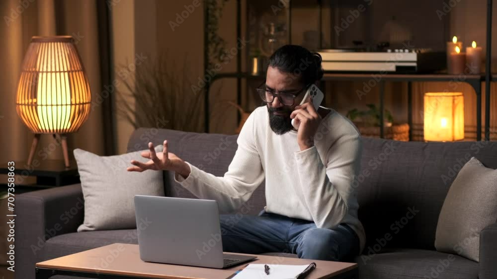 Preoccupied businessman multitasks, engrossed in a phone call and work on laptop. His expressions reveal a sense of distraction, capturing the dynamic and busy nature of the evening work routine. Preoccupied businessman multitasks, engrossed in a phone call and work on laptop. His expressions reveal a sense of distraction, capturing the dynamic and busy nature of the evening work routine.