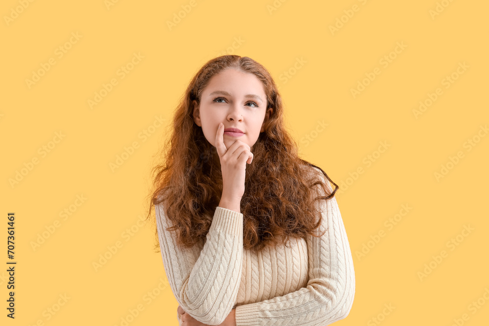 Portrait of thoughtful redhead woman on yellow background Portrait of thoughtful redhead woman on yellow background
