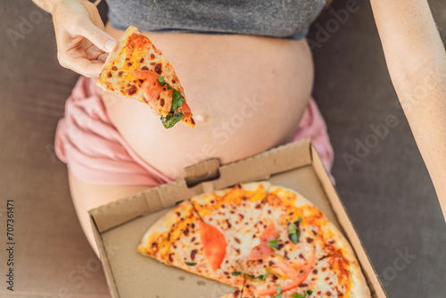 A pregnant woman enjoys a slice of pizza, savoring a moment of indulgence while satisfying her craving for a delightful, comforting treat. Excited Pregnant Young Lady Enjoying Pizza Holding Biting
