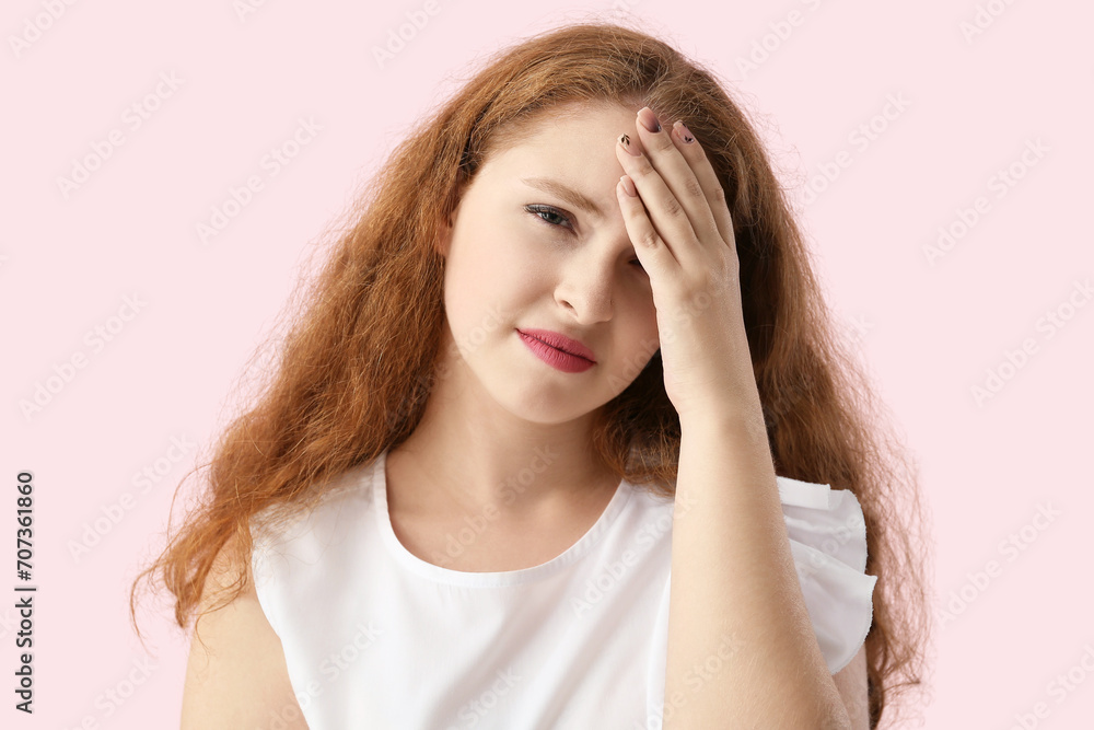 Portrait of pretty redhead woman suffering from headache on pink background Portrait of pretty redhead woman suffering from headache on pink background