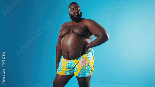 Plus size black male model posing confidently in summer shorts