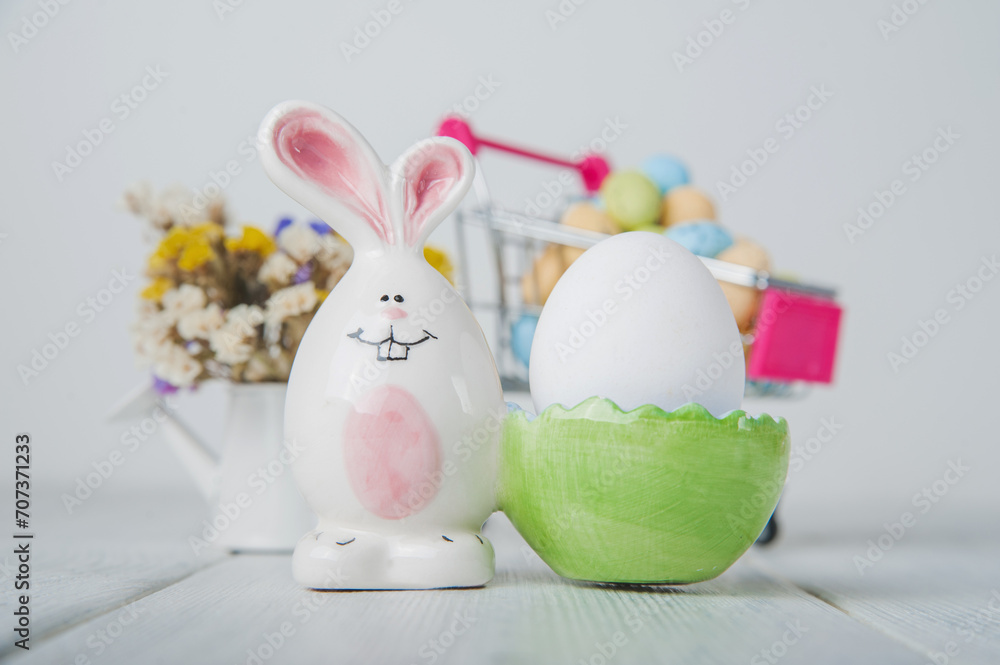 Happy Easter greeting card. Miniature wooden house. Rabbits, colorful eggs, spring flowers with tag for text Happy Easter greeting card. Miniature wooden house. Rabbits, colorful eggs, spring flowers with tag for text