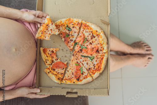 Fotografi A pregnant woman enjoys a slice of pizza, savoring a moment of indulgence while satisfying her craving for a delightful, comforting treat