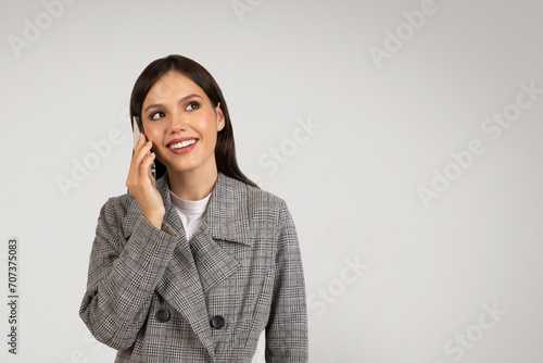 Smiling businesswoman talking on phone in stylish blazer