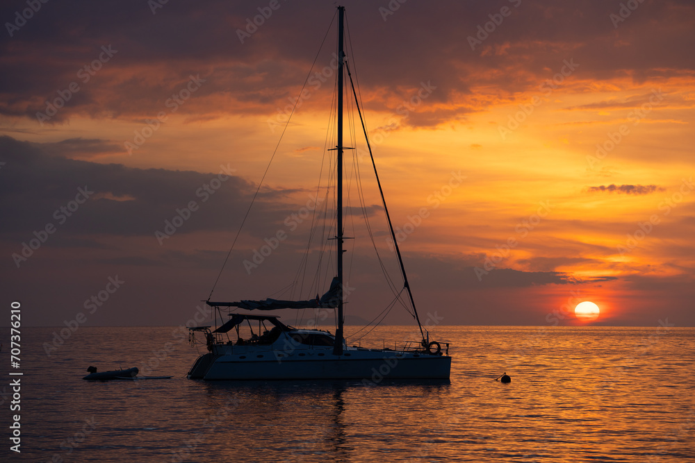 Silhouette of a sailing boat in sunset on the Andaman Sea at Yao Beach west coast of Thailand, Hat Chao Mai National Park Trang Province Thailand.