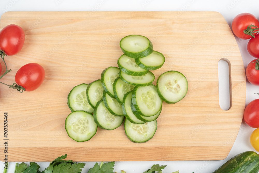 Sliced cucumber pieces on a cutting board. Preparing the salad. Sliced cucumber pieces on a cutting board. Preparing the salad.