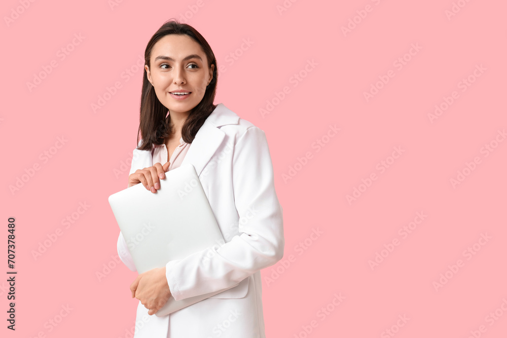 Young businesswoman with laptop on pink background Young businesswoman with laptop on pink background