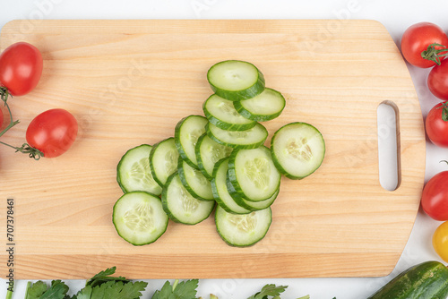 Sliced cucumber pieces on a cutting board. Preparing the salad.