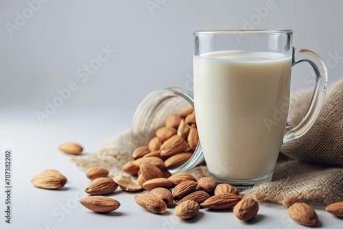 Almond milk and nuts on white background promoting healthy drinks