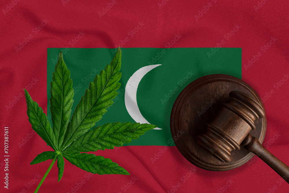 Judicial wooden gavel, fresh hemp leaf and Maldives flag. Illegal sale and distribution of marijuana