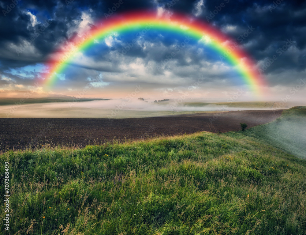 Obraz premium Beautiful rainbow over the field. Agricultural landscape. Nature of Ukraine