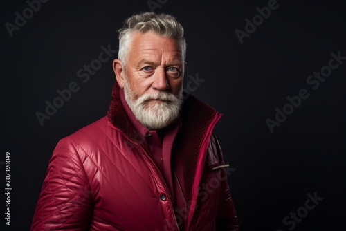 Portrait of a senior man in a red jacket. Studio shot.