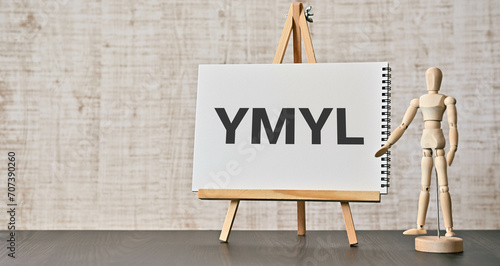 There is wood block with the word YMYL. It is an abbreviation for Your Money or Your Life as eye-catching image. photo