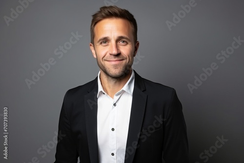 Portrait of a handsome man in a suit on a gray background