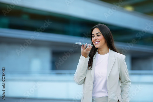 Arabic Businesswoman Using Voice Search Application On Phone Outdoors