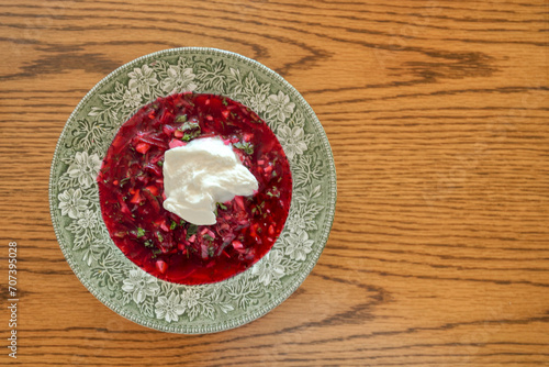 A traditional dish of Ukrainian cuisine - borsch. Soup with beets, meat, potatoes and beans. Served with sour cream and garlic. Close-up photo