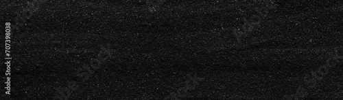 Dark black sand. Flat and smooth volcanic sand texture or wallpaper.