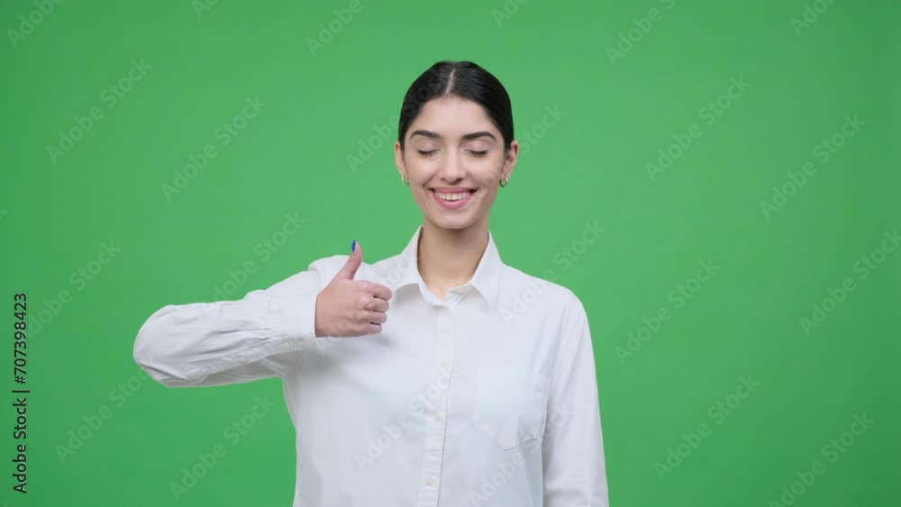 Business clad Caucasian woman on green background confidently makes the thumbs up gesture, expressing approval or satisfaction. Her professionalism and positivity, conveying success. Business clad Caucasian woman on green background confidently makes the thumbs up gesture, expressing approval or satisfaction. Her professionalism and positivity, conveying success.
