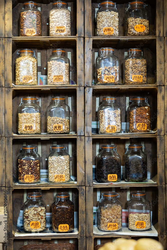 Various nuts and dried fruits neatly arranged in jars on shelves