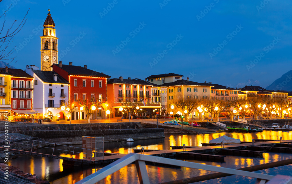 Townscape of Ascona, Switzerland. View of Lake Maggiore, embankment and Church of Saints Peter and Paul in evening.