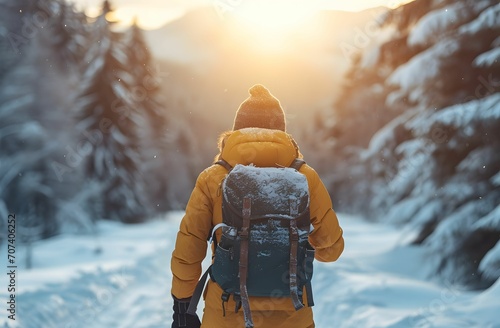 Winter Wanderlust - Person with Backpack Walking Towards the Sun in Snow, Embracing Dark Yellow and Light Indigo Tones