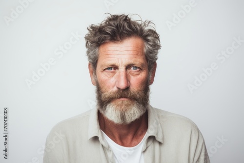 Portrait of mature man with gray beard and mustache looking at camera.