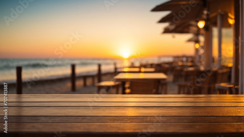 Wooden table top on blur beach cafes background at sunset - can be used for display or montage your products © anandart