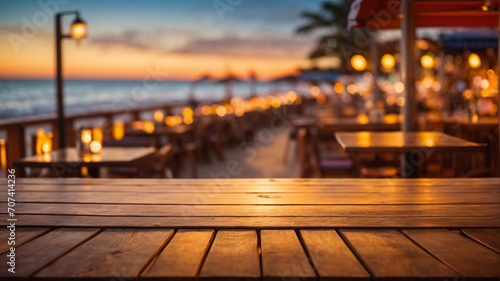 Wooden table top on blur beach cafes background at sunset - can be used for display or montage your products