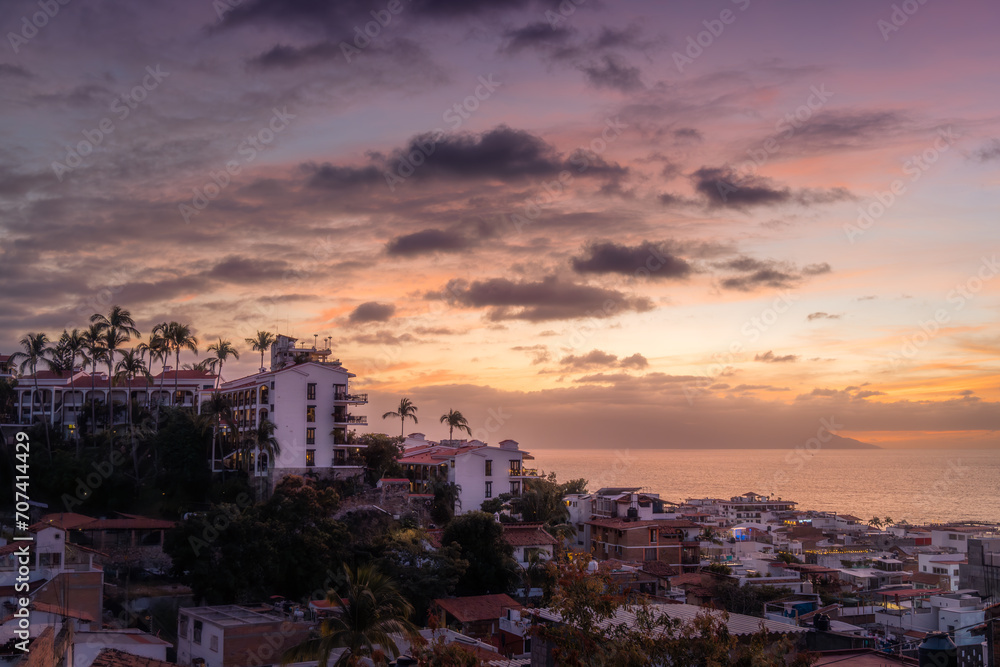 Dramatic Sunset over cityscape of Puerto Vallarta Jalisco Mexico in January with orange and purple hues.