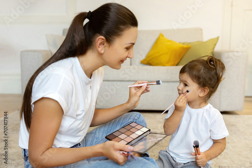 Schilderij op canvas Little Girl Playing With Mom's Makeup Cosmetics And Brushes At Home