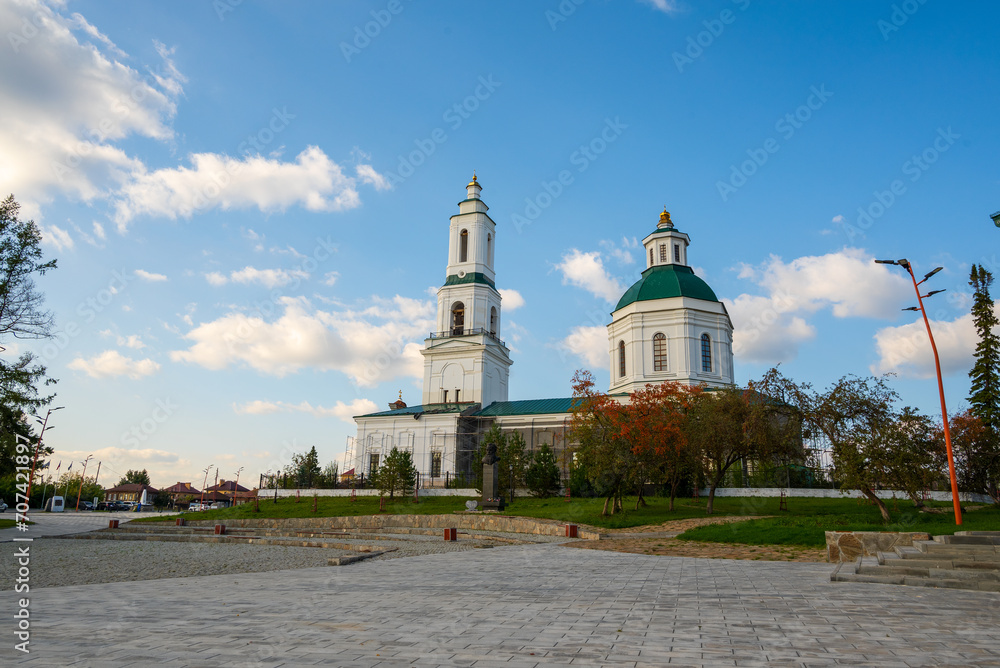 Russian Orthodox church on the stone square against the background of blue sky with clouds