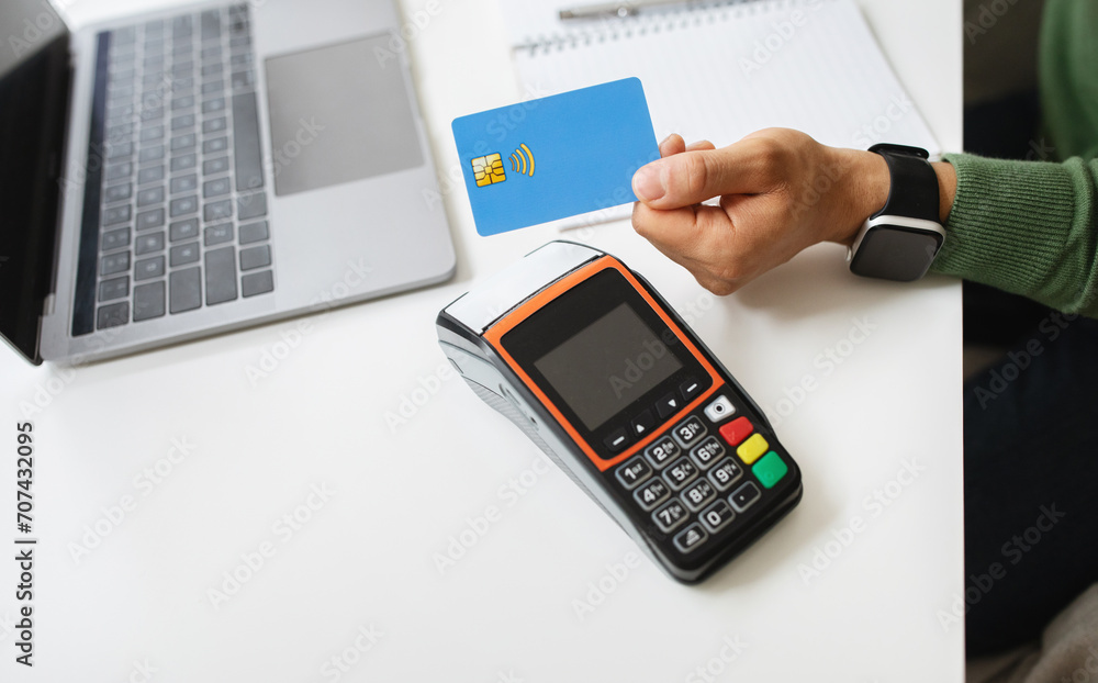 Customer using credit card for payment to owner at cafe Customer using credit card for payment to owner at cafe