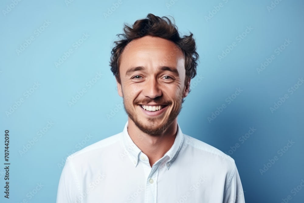 Portrait of a handsome young man laughing against a blue background. Portrait of a handsome young man laughing against a blue background.