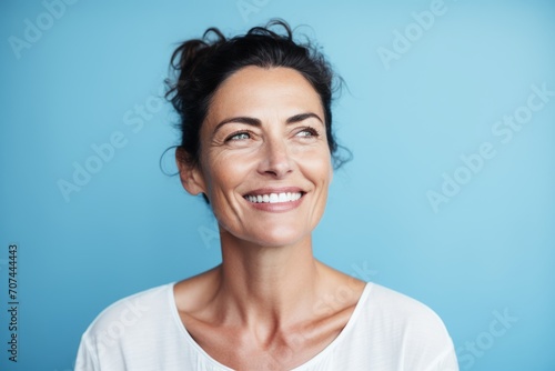Portrait of a happy mature woman smiling at the camera over blue background