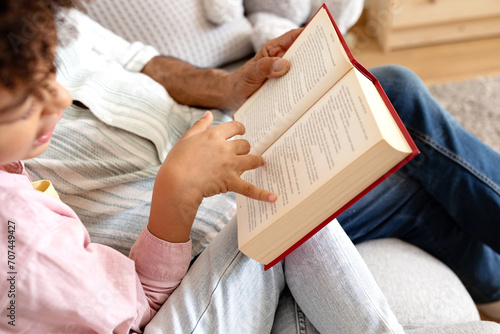 Cropped of senior man and boy reading book at home