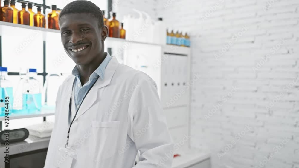 A smiling african man in a white lab coat stands in a clean, white laboratory, surrounded by scientific equipment. A smiling african man in a white lab coat stands in a clean, white laboratory, surrounded by scientific equipment.