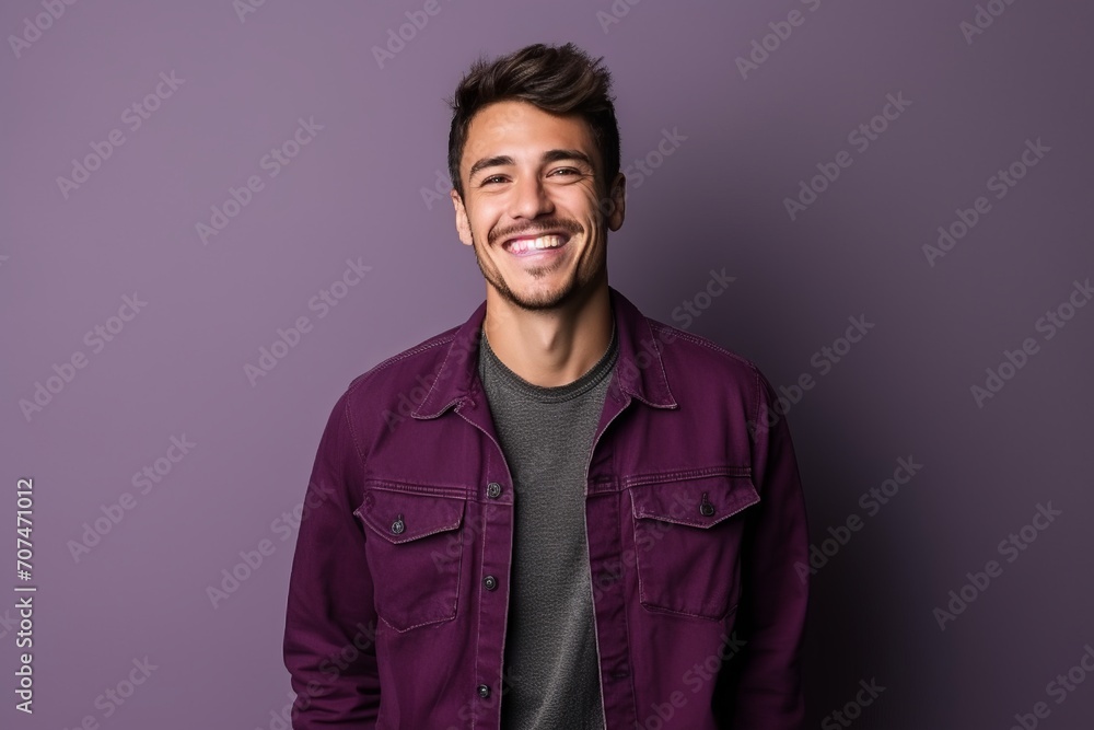 Portrait of a handsome young man smiling against a purple background. - obrazy, fototapety, plakaty 