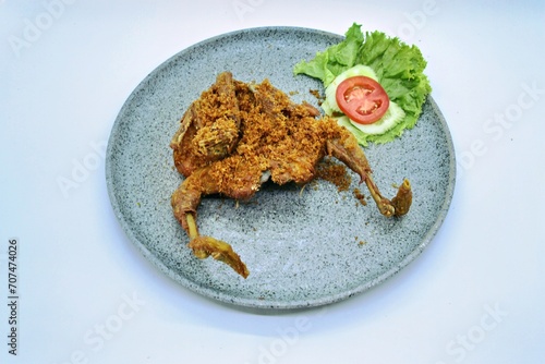 Ayam Goreng Lengkuas Kremes or Galangal Fried Chicken, One of Indonesia's culinary icons from the city of Bandung. This fried chicken sprinkled with serundeng comes from grated galangal. photo