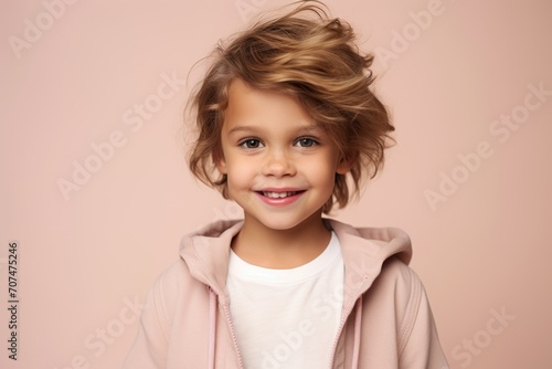 Studio portrait of a cute little girl in a pink hoodie.