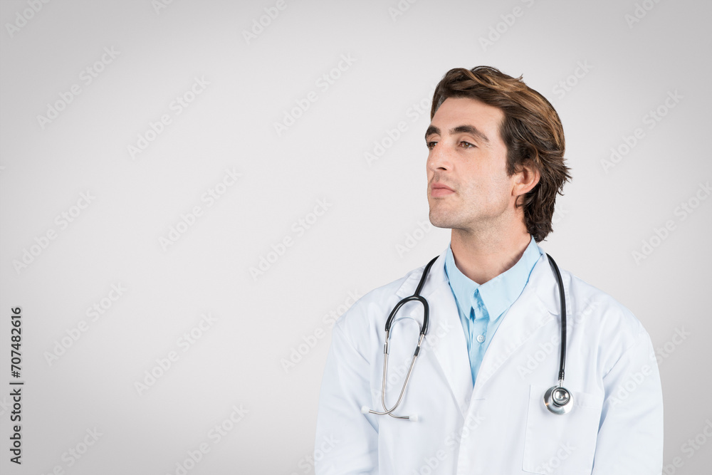 Thoughtful caucasian male doctor in white coat with stethoscope Thoughtful caucasian male doctor in white coat with stethoscope