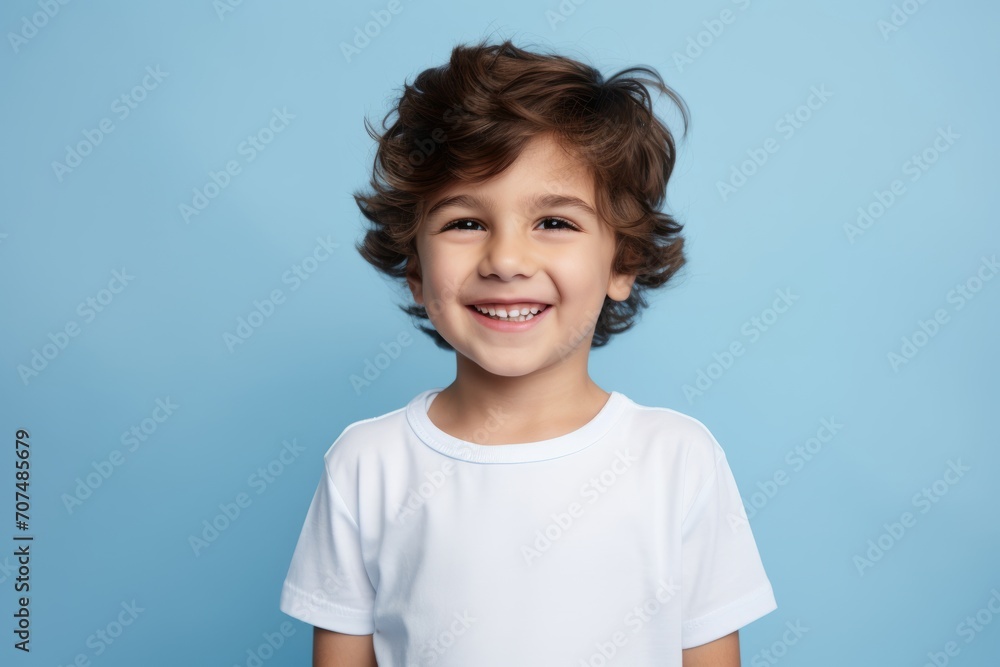 Portrait of a smiling little boy in a white t-shirt on a blue background Portrait of a smiling little boy in a white t-shirt on a blue background