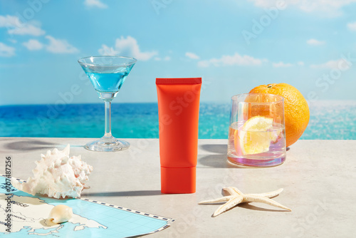 Front view of sunscreen tube displayed with a map, glasses of beverages and an orange. Starfishes and conch shells. The concept of summer recreation, activity near the water